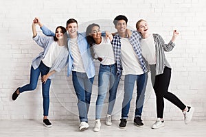 Happy teenagers having fun and posing over white wall photo