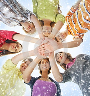 Happy teenagers holding hands together on the snow