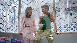 Happy teenagers laughing together in laundry room. Cheerful girl guy washing