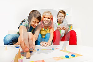 Happy teenagers play table game together at home