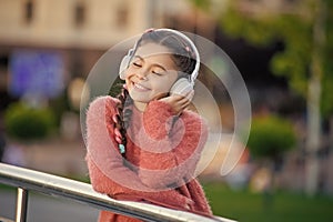 Happy teener enjoy listening to music. Melomaniac teenager listening song outdoors