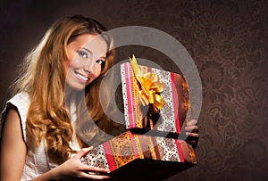 A happy teenge girl opening a Christmas present