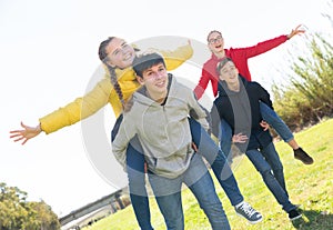 Happy teens compete with each other in park