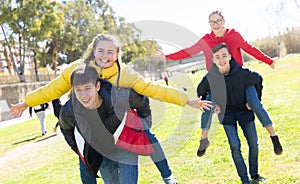 Happy teens compete with each other in park