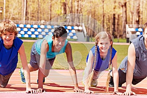 Happy teens doing push-up exercises on the track