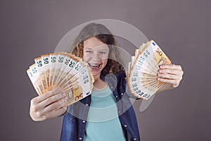 Happy teens girl holds in her hand euro
