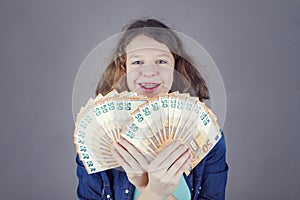 Happy teens girl holds in her hand euro