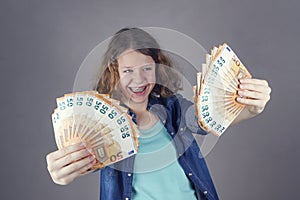 Happy teens girl holds in her hand euro