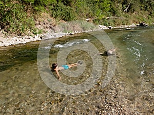 Happy teens having fun swimming in the river water