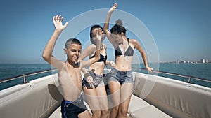 Happy teens are having the time of their lives dancing on a boat