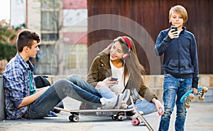 Happy teens playing on smarthphones and listening to music