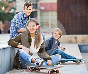 Happy teens playing on smarthphones and listening to music