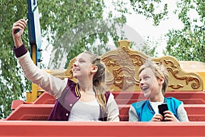 Happy Teens ride on the carousel and make selfie