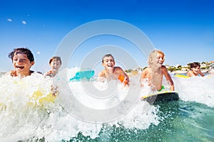 Happy teens riding the waves on body boards