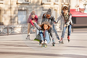 Happy teens rollerblading and skateboarding