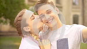 Happy teens taking selfie, looking at camera and kissing, tenderness, memories