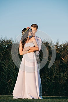 happy tender young wedding couple embracing and smiling