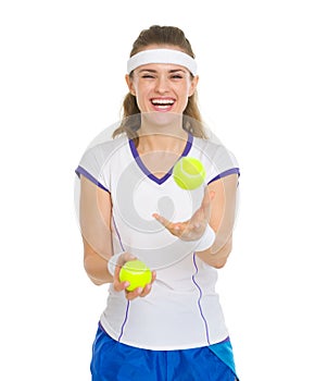 Happy tennis player joggling with tennis balls