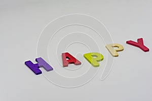 The HAPPY text from colorful wooden letters is on white background