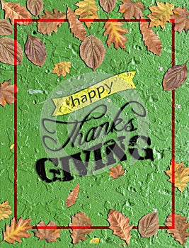 Happy thanks giving written on green concrete with several leaves