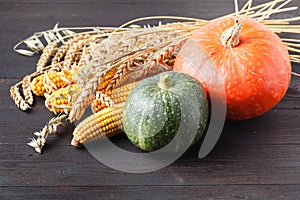 Happy Thanksgiving Day background, wooden table decorated with Pumpkins, Corncob, Candles and autumn leaves garland. Beautiful Hol