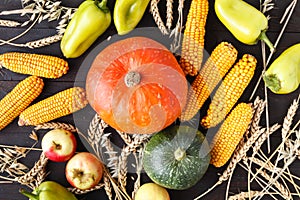 Happy Thanksgiving Day background, wooden table decorated with Pumpkins, Corncob, Candles and autumn leaves garland. Beautiful Hol