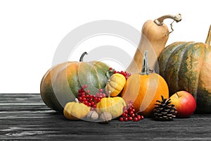 Happy Thanksgiving day. Composition with pumpkins and berries on black wooden table against white background