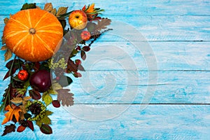 Happy Thanksgiving greeting with fall leaves on blue wooden bac