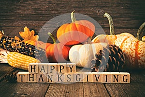 Happy Thanksgiving greeting against rustic wood with pumpkins and autumn decor. Vintage style. photo