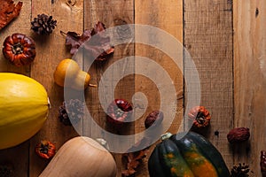 Happy Thanksgiving. Pumpkins, cones and dry leaves on a wooden background. View from above. Flat layer