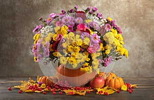 happy thanksgiving still life. autumn flowers roses, chrysanthemums, asters in a pumpkin vase