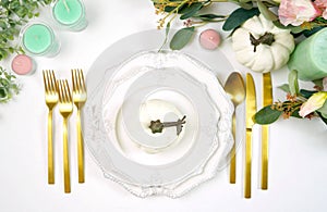 Happy Thanksgiving table setting with modern white pumpkins centerpiece.