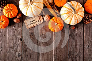 Happy Thanksgiving tag with autumn top border of pumpkins and fall decor on a rustic wood background