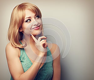 Happy thinking young woman with blond short hairstyle looking wi