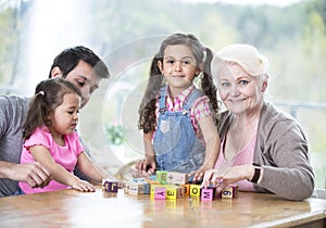 Happy three generation family playing with alphabet blocks at home