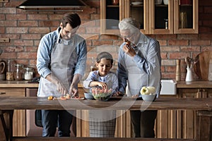 Happy three generations of men cooking in kitchen together