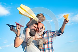 Happy three generations of men have fun and smiling on blue sky background. Enjoy family together. Dream of flying. Kids