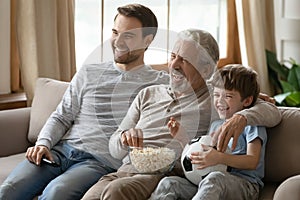 Happy three generations of men watch football together