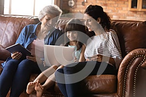 Happy three generations of women having fun with gadgets together