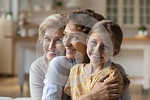 Happy three generations of women hug cuddle
