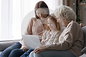 Happy three generations of women using laptop at home