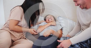 Happy, tickling and parents with child on bed at family home on a weekend morning together. Love, smile and young mother