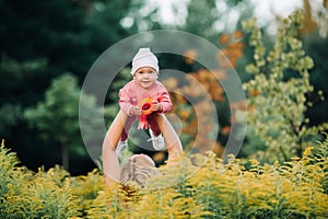 Happy time together. Mother playing with her baby, holding kid on hands