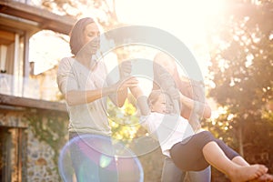 Happy to be with granny and mom. Shot of a little girl playing outside with her mother and grandmother.