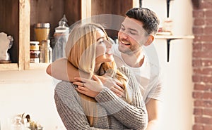 Happy to be in love. Spouses embracing in kitchen on sunny morning, panorama