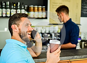 Happy to hear you. Confident entrepreneur choose drink in paper cup to go while communicate mobile. Man speak mobile