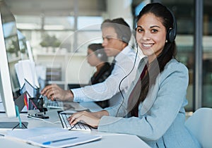 Happy to hear from you. Portrait of a happy and confident young woman working in a call center.