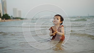 happy toddler baby girl playing sand and water on sea beach