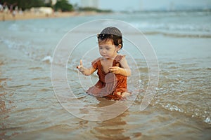 happy toddler baby girl playing sand and water on sea beach