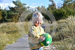 Happy toddler boy playing with a ball